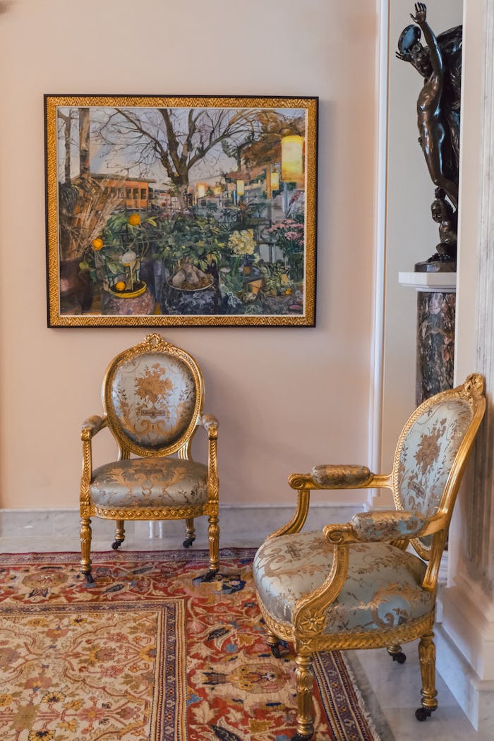 Two ornate vintage chairs in an opulent museum setting, showcasing classic luxury.